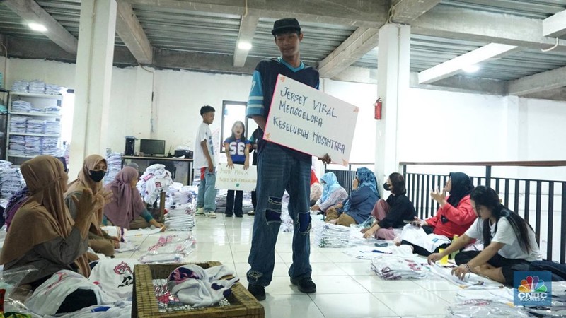 Sejumlah selebgram membawa tulisan penyemangat bagi pekerja dan pelaku IKM (Industri Kecil Menengah) di industri konveksi rumahan Sinergi Adv Nusantara, Jakarta, Rabu (30/4/2025). (վ/Muhammad Sabki)