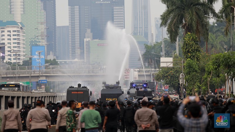 Petugas kepolisian membubarkan aksi massa demo May Day dengan water canon di depan Gedung DPR, Jakarta, (1/5/2025). (CNBC Indonesia/Muhammad Sabki)