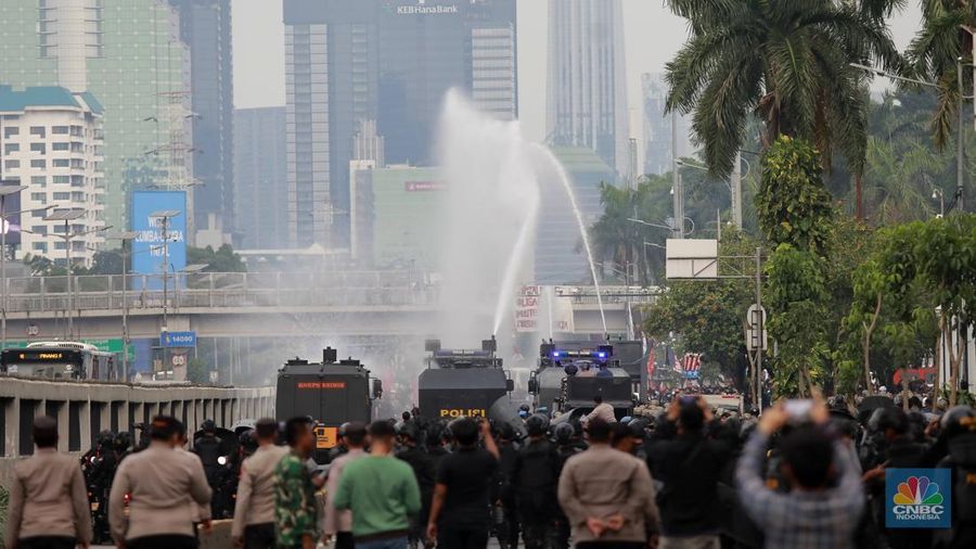 Petugas kepolisian membubarkan aksi massa demo May Day dengan water canon di depan Gedung DPR, Jakarta, (1/5/2025). (CNBC Indonesia/Muhammad Sabki)