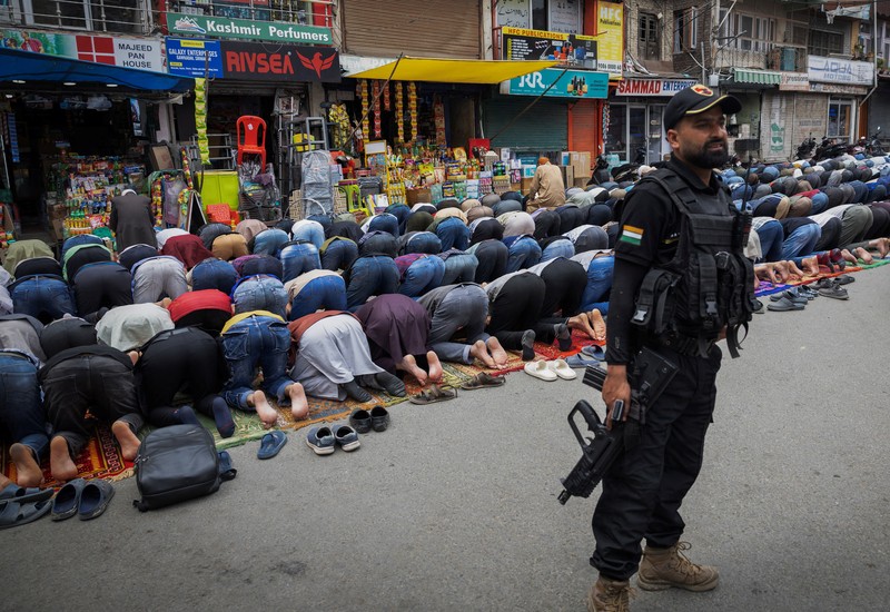 Umat ​​Muslim Kashmir melaksanakan salat Jumat di jalan sementara petugas keamanan berjaga di Srinagar, 2 Mei 2025. (REUTERS/Adnan Abidi)