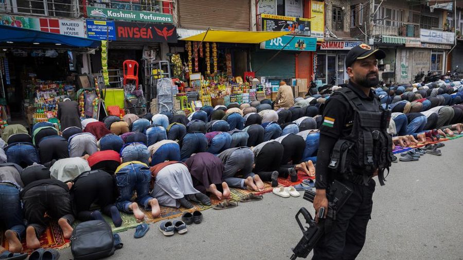 Umat ​​Muslim Kashmir melaksanakan salat Jumat di jalan sementara petugas keamanan berjaga di Srinagar, 2 Mei 2025. (REUTERS/Adnan Abidi)