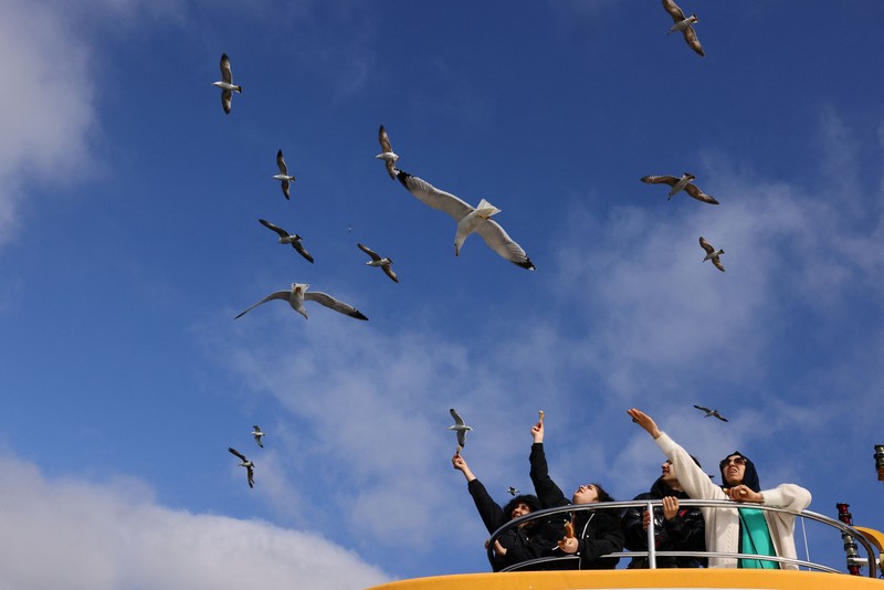Orang-orang memberi makan burung camar saat mereka berlayar melalui Bosphorus dengan feri di Istanbul, Turki, 23 April 2025. (REUTERS/Umit Bektas) Orang-orang memberi makan burung camar saat mereka berlayar melalui Bosphorus dengan feri di Istanbul, Turki, 23 April 2025. (REUTERS/Umit Bektas)