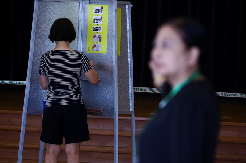 Warga memberikan suaranya di tempat pemungutan suara selama pemilihan umum di Singapura, Sabtu (3/5/2025). (REUTERS/Edgar Su)