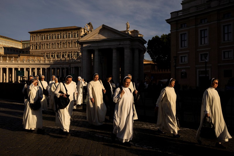 Para biarawati berjalan di luar Lapangan Santo Petrus di Vatikan menjelang konklaf dan pemilihan paus baru yang akan diadakan pada 7 Mei, seperti yang terlihat dari Roma, Italia, 3 Mei 2025. (REUTERS/Eloisa Lopez)