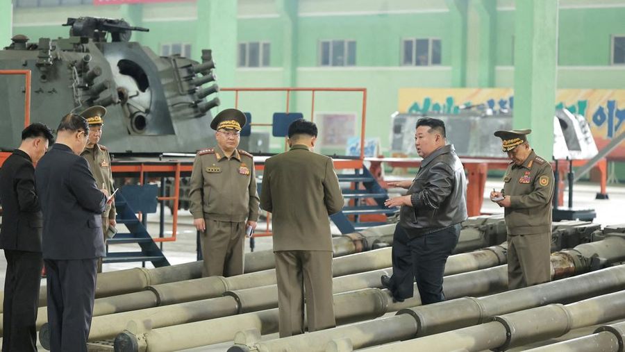 Pemimpin Korea Utara Kim Jong Un berjalan di dekat peluncur rudal bergerak saat ia mengunjungi militer Pemimpin Korea Utara Kim Jong Un mengunjungi pabrik tank. Kim Jong Un memuji kemajuan besar tank-tank yang diproduksi pabrik tersebut. (via REUTERS/KCNA)