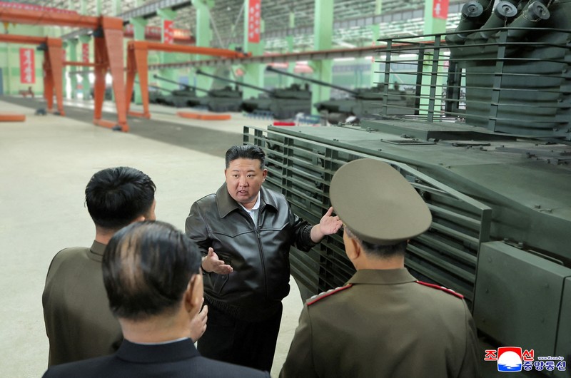 Pemimpin Korea Utara Kim Jong Un berjalan di dekat peluncur rudal bergerak saat ia mengunjungi militer Pemimpin Korea Utara Kim Jong Un mengunjungi pabrik tank. Kim Jong Un memuji kemajuan besar tank-tank yang diproduksi pabrik tersebut. (via REUTERS/KCNA)