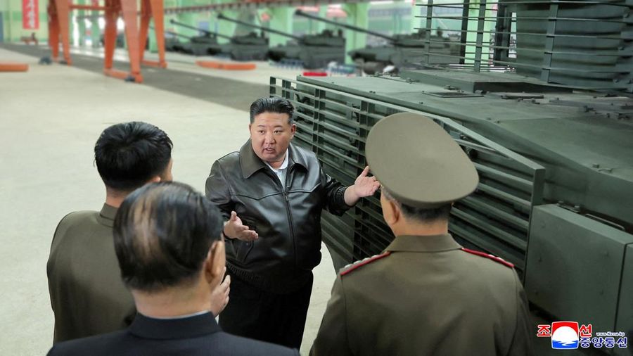 Pemimpin Korea Utara Kim Jong Un berjalan di dekat peluncur rudal bergerak saat ia mengunjungi militer Pemimpin Korea Utara Kim Jong Un mengunjungi pabrik tank. Kim Jong Un memuji kemajuan besar tank-tank yang diproduksi pabrik tersebut. (via REUTERS/KCNA)