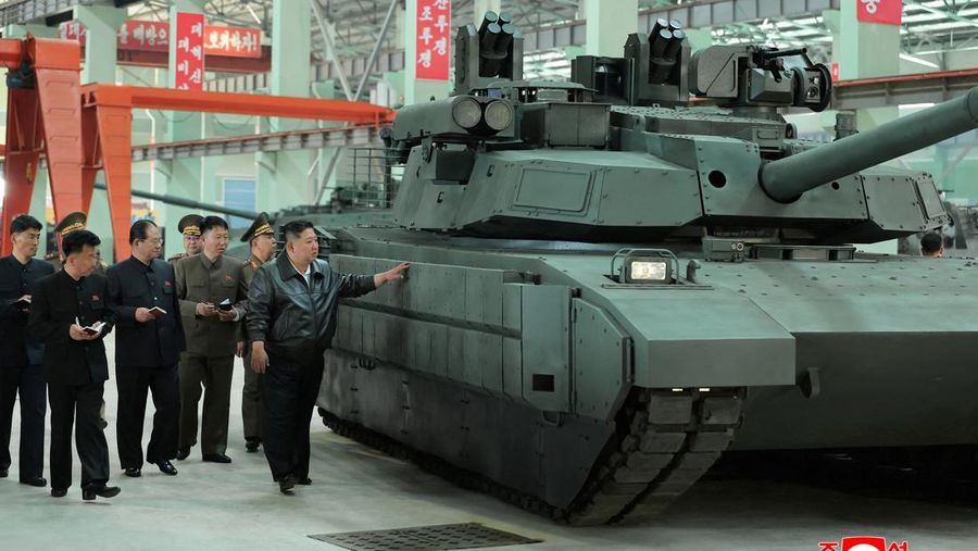 Pemimpin Korea Utara Kim Jong Un berjalan di dekat peluncur rudal bergerak saat ia mengunjungi militer Pemimpin Korea Utara Kim Jong Un mengunjungi pabrik tank. Kim Jong Un memuji kemajuan besar tank-tank yang diproduksi pabrik tersebut. (via REUTERS/KCNA)