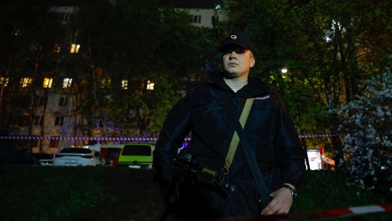 Petugas pemadam kebakaran bekerja di lantai di atas blok apartemen yang seperti merusak di belakang dugaan ledakan gas di Moskow, Rusia, 4 Mei 2025. (REUTERS/Maxim Shemetov)