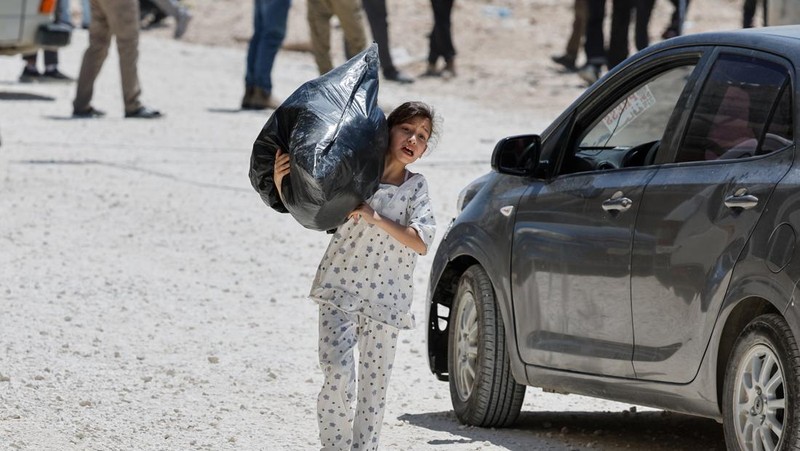 Warga Palestina membawa barang-barang mereka setelah keputusan Israel untuk menghancurkan rumah mereka di kamp Nur Shams, Selasa (6/5/2025). (REUTERS/Raneen Sawafta)