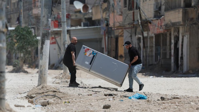 Warga Palestina membawa barang-barang mereka setelah keputusan Israel untuk menghancurkan rumah mereka di kamp Nur Shams, Selasa (6/5/2025). (REUTERS/Raneen Sawafta)