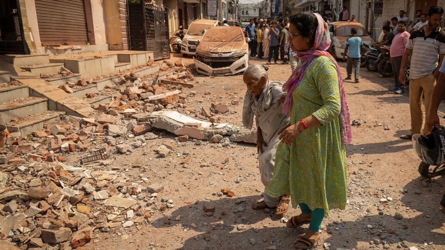 Women walk towards their damaged house, following Pakistan's military operation against India, in Rehari, Jammu, May 10, 2025. REUTERS/Adnan Abidi