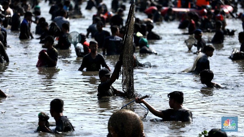 Tradisi ngubek empang di Situ Pengasinan Depok, Jawa Barat, Minggu (11/5/2025). (CNBC Indonesia/Tri Susilo)