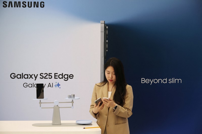 SAMSUNG ELEC-PHONES/ A reporter tries out a Samsung Electronics’ Galaxy S25 Edge during an event at its store in Seoul, South Korea, May 13, 2025. REUTERS/Kim Hong-Ji