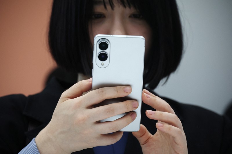 SAMSUNG ELEC-PHONES/ A reporter tries out a Samsung Electronics’ Galaxy S25 Edge during an event at its store in Seoul, South Korea, May 13, 2025. REUTERS/Kim Hong-Ji