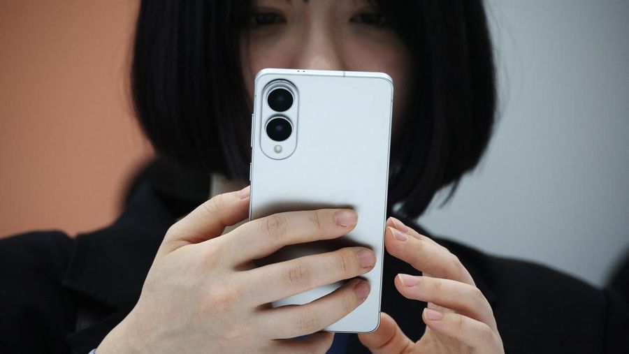 A reporter tries out a Samsung Electronics’ Galaxy S25 Edge during an event at its store in Seoul, South Korea, May 13, 2025.    REUTERS/Kim Hong-Ji