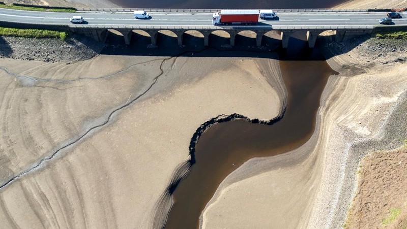 Pemandangan drone menunjukkan kendaraan menggunakan jembatan untuk melewati bagian Waduk Woodhead yang sebagian kering setelah periode panjang tanpa hujan, yang mengakibatkan turunnya permukaan air, dekat Tintwistle, Inggris, 13 Mei 2025. (REUTERS/Phil Noble)