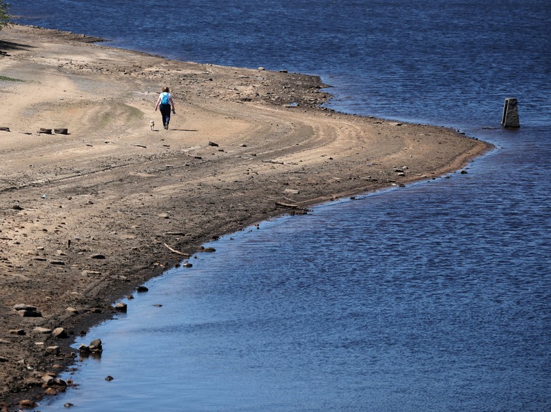 Pemandangan drone menunjukkan kendaraan menggunakan jembatan untuk melewati bagian Waduk Woodhead yang sebagian kering setelah periode panjang tanpa hujan, yang mengakibatkan turunnya permukaan air, dekat Tintwistle, Inggris, 13 Mei 2025. (REUTERS/Phil Noble)
