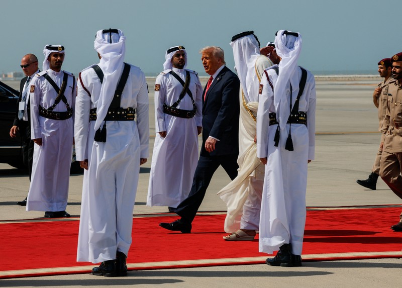 Presiden AS Donald Trump berjalan bersama Emir Qatar Tamim bin Hamad Al Thani saat tiba di Bandara Internasional Hamad, di Doha, Qatar, 14 Mei 2025. REUTERS/Brian Snyder