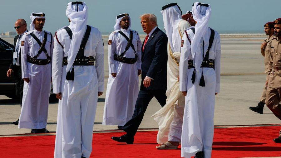 Presiden AS Donald Trump berjalan bersama Emir Qatar Tamim bin Hamad Al Thani saat tiba di Bandara Internasional Hamad, di Doha, Qatar, 14 Mei 2025. REUTERS/Brian Snyder
