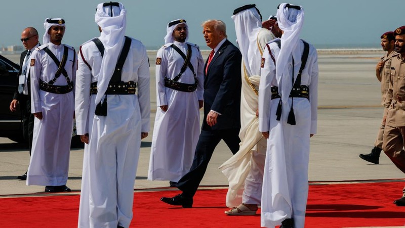 Presiden AS Donald Trump berjalan bersama Emir Qatar Tamim bin Hamad Al Thani saat tiba di Bandara Internasional Hamad, di Doha, Qatar, 14 Mei 2025. REUTERS/Brian Snyder