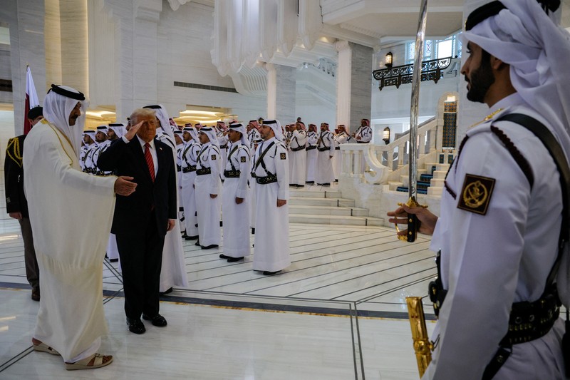 Presiden AS Donald Trump berjalan bersama Emir Qatar Tamim bin Hamad Al Thani saat tiba di Bandara Internasional Hamad, di Doha, Qatar, 14 Mei 2025. REUTERS/Brian Snyder