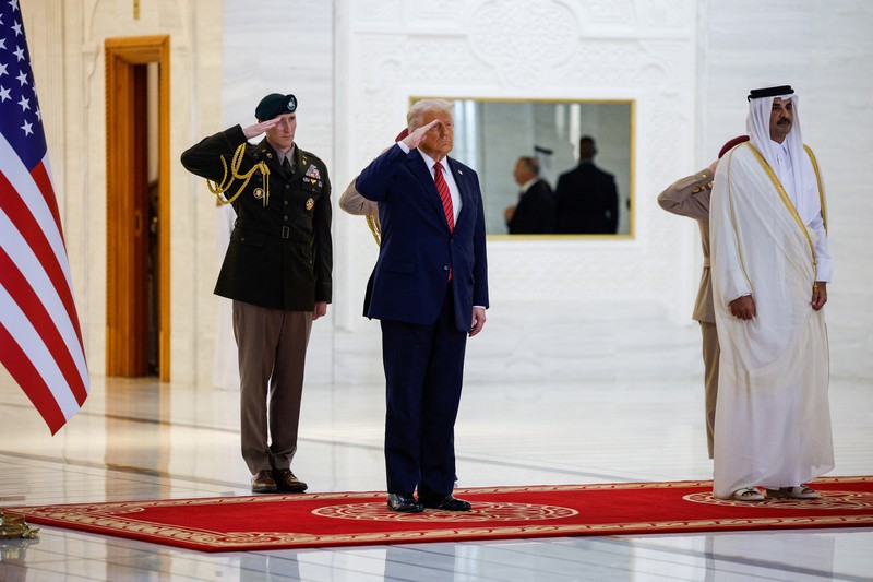 Presiden AS Donald Trump berjalan bersama Emir Qatar Tamim bin Hamad Al Thani saat tiba di Bandara Internasional Hamad, di Doha, Qatar, 14 Mei 2025. REUTERS/Brian Snyder