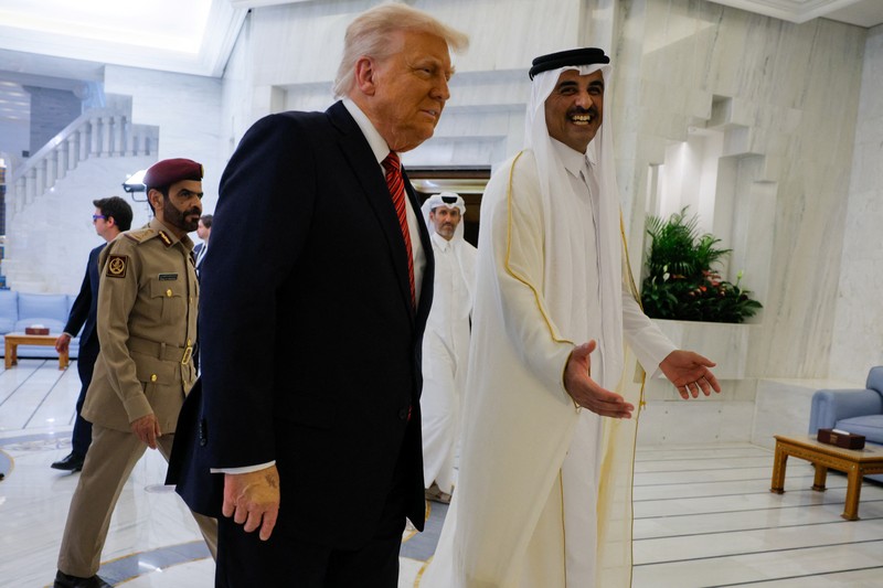 USA-TRUMP/GULF Presiden AS Donald Trump berjalan bersama Emir Qatar Tamim bin Hamad Al Thani saat tiba di Bandara Internasional Hamad, di Doha, Qatar, 14 Mei 2025. REUTERS/Brian Snyder