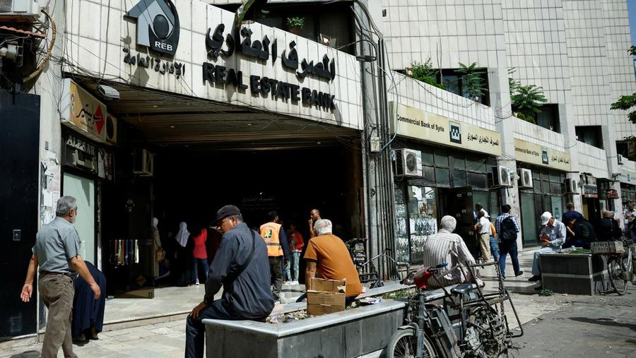 Warga berkumpul di mesin ATM Bank Komersial Suriah untuk menarik uang, setelah Presiden AS Donald Trump mengumumkan bahwa ia akan memerintahkan pencabutan sanksi terhadap Suriah, di Damaskus, Suriah, 14 Mei 2025. REUTERS/Yamam al ShaarREUTERS/Yamam al Shaar