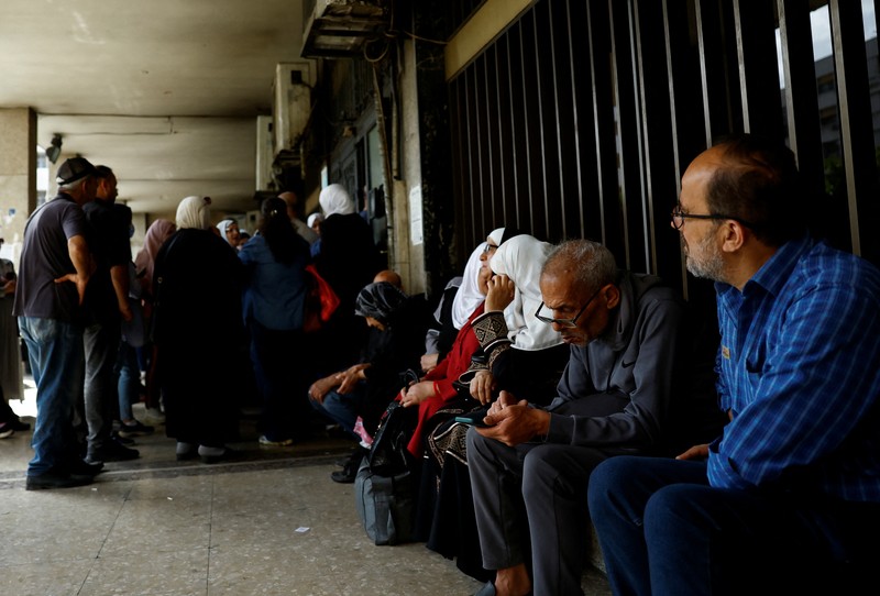 USA-TRUMP/SYRIA Warga berkumpul di mesin ATM Bank Komersial Suriah untuk menarik uang, setelah Presiden AS Donald Trump mengumumkan bahwa ia akan memerintahkan pencabutan sanksi terhadap Suriah, di Damaskus, Suriah, 14 Mei 2025. REUTERS/Yamam al ShaarREUTERS/Yamam al Shaar