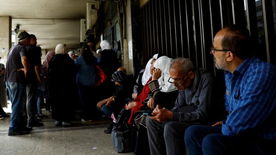 USA-TRUMP/SYRIA Warga berkumpul di mesin ATM Bank Komersial Suriah untuk menarik uang, setelah Presiden AS Donald Trump mengumumkan bahwa ia akan memerintahkan pencabutan sanksi terhadap Suriah, di Damaskus, Suriah, 14 Mei 2025. REUTERS/Yamam al ShaarREUTERS/Yamam al Shaar