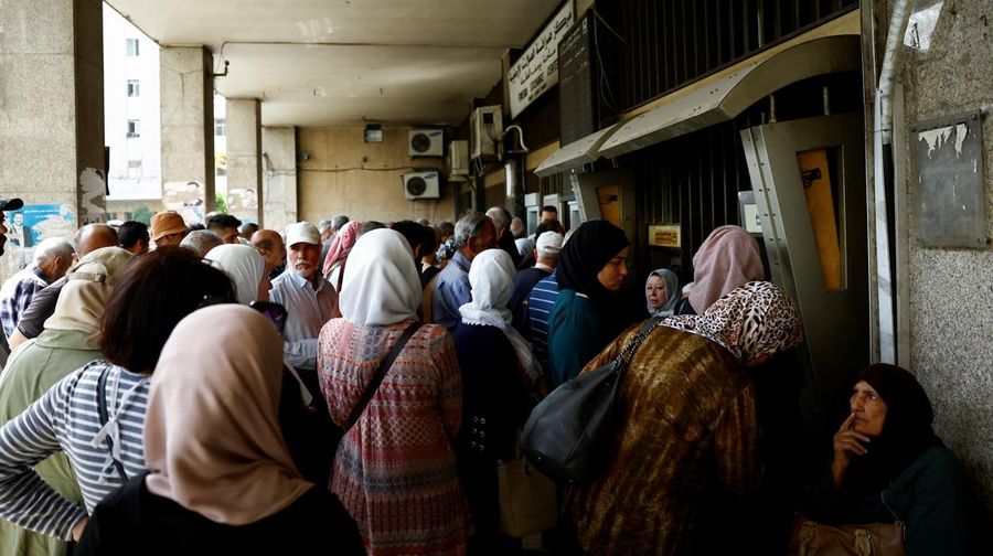 USA-TRUMP/SYRIA Warga berkumpul di mesin ATM Bank Komersial Suriah untuk menarik uang, setelah Presiden AS Donald Trump mengumumkan bahwa ia akan memerintahkan pencabutan sanksi terhadap Suriah, di Damaskus, Suriah, 14 Mei 2025. REUTERS/Yamam al ShaarREUTERS/Yamam al Shaar