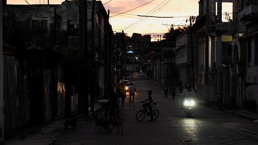 People walk on the street during a blackout in Havana, Cuba, May 13, 2025. REUTERS/Norlys Perez