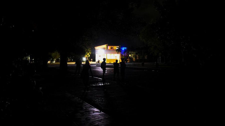 People walk on the street during a blackout in Havana, Cuba, May 13, 2025. REUTERS/Norlys Perez