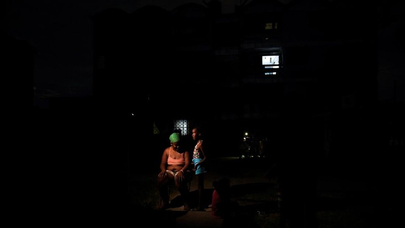People walk on the street during a blackout in Havana, Cuba, May 13, 2025. REUTERS/Norlys Perez