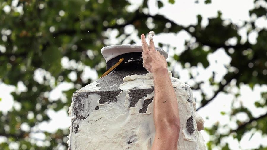 Para anggota Plebe berlomba untuk memulai tugas mereka membentuk piramida manusia untuk memanjat Monumen Herndon, sebuah obelisk granit setinggi 21 kaki, yang dilapisi dengan lapisan tebal lemak nabati, dalam ritual tahunan yang menandai selesainya kelas tahun pertama di Akademi Angkatan Laut AS di Annapolis, Maryland, AS, 14 Mei 2025. (REUTERS/Kevin Lamarque)