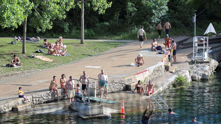 Seorang pria menyelam ke air dari papan loncat di Barton Springs, di tengah gelombang panas, di Austin, Texas, AS, 14 Mei 2025. (REUTERS/Evan Garcia)