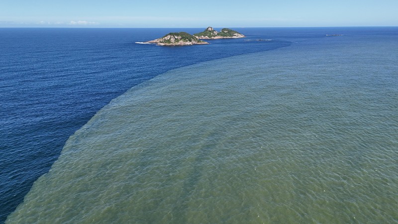 Pemandangan drone menunjukkan tongkang bekerja mengeruk laguna Barra dan Jacarepagua, saat air dari laguna tersebut menodai laut menjadi hijau di lepas pantai Barra da Tijuca, menurut media lokal, di Rio de Janeiro, Brasil, 15 Mei 2025. (REUTERS/Ricardo Moraes)