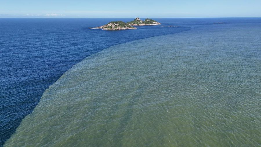 Pemandangan drone menunjukkan tongkang bekerja mengeruk laguna Barra dan Jacarepagua, saat air dari laguna tersebut menodai laut menjadi hijau di lepas pantai Barra da Tijuca, menurut media lokal, di Rio de Janeiro, Brasil, 15 Mei 2025. (REUTERS/Ricardo Moraes)
