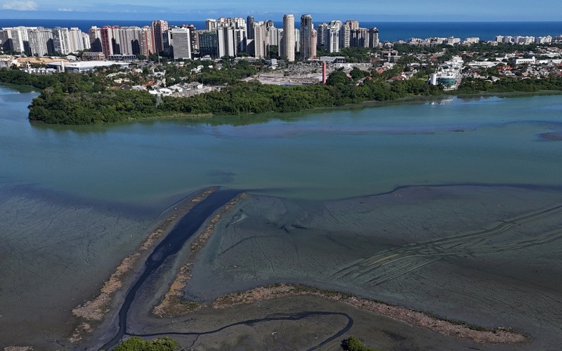 Pemandangan drone menunjukkan tongkang bekerja mengeruk laguna Barra dan Jacarepagua, saat air dari laguna tersebut menodai laut menjadi hijau di lepas pantai Barra da Tijuca, menurut media lokal, di Rio de Janeiro, Brasil, 15 Mei 2025. (REUTERS/Ricardo Moraes)