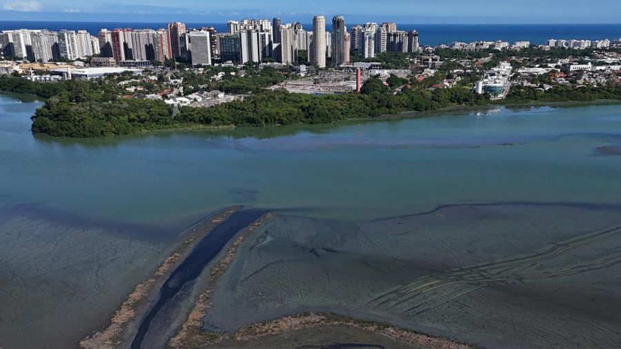 Pemandangan drone menunjukkan tongkang bekerja mengeruk laguna Barra dan Jacarepagua, saat air dari laguna tersebut menodai laut menjadi hijau di lepas pantai Barra da Tijuca, menurut media lokal, di Rio de Janeiro, Brasil, 15 Mei 2025. (REUTERS/Ricardo Moraes)
