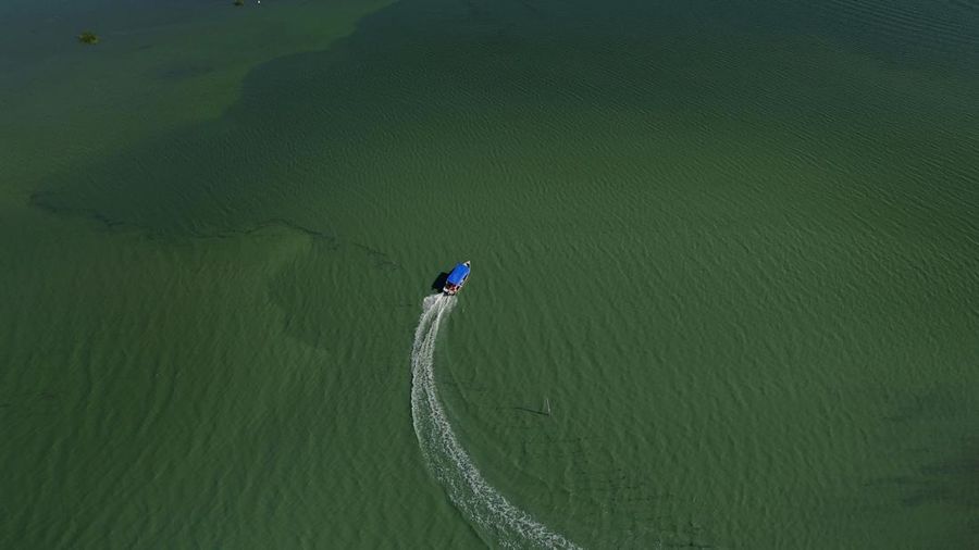 Pemandangan drone menunjukkan tongkang bekerja mengeruk laguna Barra dan Jacarepagua, saat air dari laguna tersebut menodai laut menjadi hijau di lepas pantai Barra da Tijuca, menurut media lokal, di Rio de Janeiro, Brasil, 15 Mei 2025. (REUTERS/Ricardo Moraes)