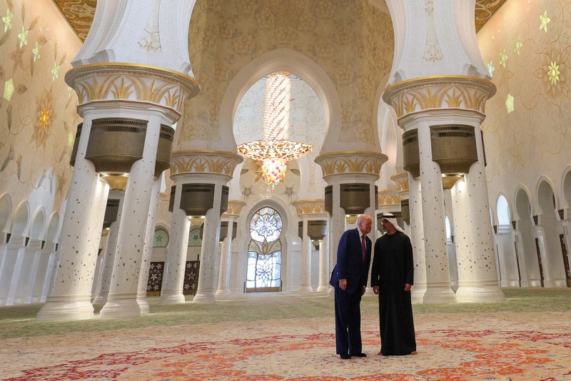 USA-TRUMP/GULF-EMIRATES U.S. President Donald Trump is reflected off the floor as he walks with Yousif Al Obaidli, director of Sheikh Zayed Grand Mosque and Ameena Al Hammadi, acting director of the Culture and Knowledge Department while visiting the Sheikh Zayed Grand Mosque in Abu Dhabi, United Arab Emirates, May 15, 2025. REUTERS/Brian Snyder