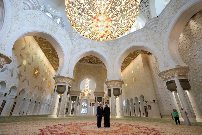 U.S. President Donald Trump is reflected off the floor as he walks with Yousif Al Obaidli, director of Sheikh Zayed Grand Mosque and Ameena Al Hammadi, acting director of the Culture and Knowledge Department while visiting the Sheikh Zayed Grand Mosque in Abu Dhabi, United Arab Emirates, May 15, 2025. REUTERS/Brian Snyder