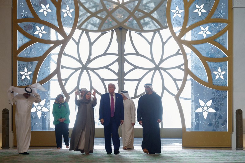 U.S. President Donald Trump is reflected off the floor as he walks with Yousif Al Obaidli, director of Sheikh Zayed Grand Mosque and Ameena Al Hammadi, acting director of the Culture and Knowledge Department while visiting the Sheikh Zayed Grand Mosque in Abu Dhabi, United Arab Emirates, May 15, 2025. REUTERS/Brian Snyder