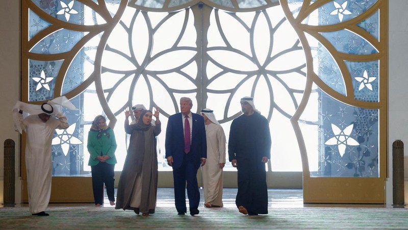 U.S. President Donald Trump is reflected off the floor as he walks with Yousif Al Obaidli, director of Sheikh Zayed Grand Mosque and Ameena Al Hammadi, acting director of the Culture and Knowledge Department while visiting the Sheikh Zayed Grand Mosque in Abu Dhabi, United Arab Emirates, May 15, 2025. REUTERS/Brian Snyder