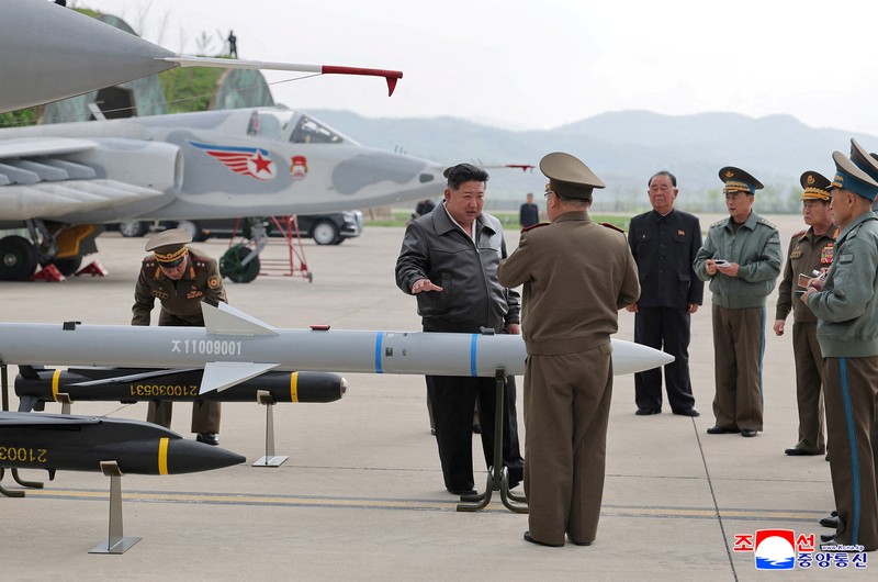 Pemimpin Korea Utara Kim Jong Un berbicara kepada anggota militer saat ia memeriksa proyektil selama kunjungan ke lapangan udara dalam foto yang dirilis oleh Kantor Berita Pusat Korea, 16 Mei 2025. (KCNA via REUTERS)