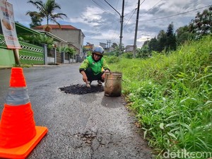 Aksi Driver Ojol Bandung Tambal Jalan Berlubang Pakai Duit Pribadi