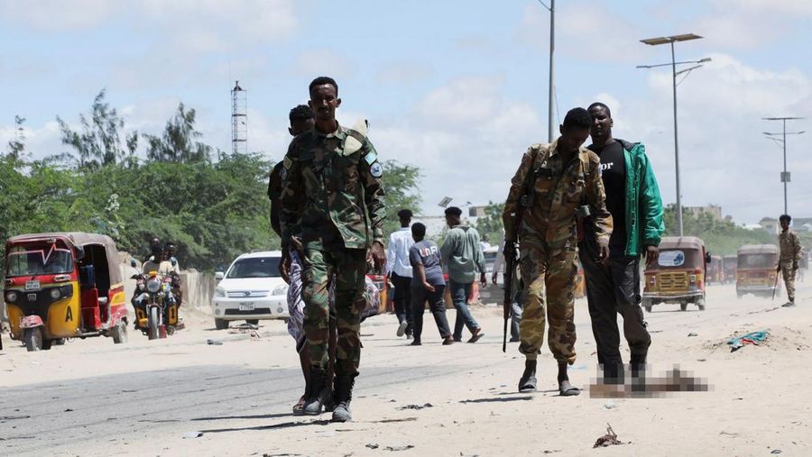 Seorang perwira militer Somalia berjalan melewati sepatu-sepatu yang ditinggalkan di lokasi ledakan yang menargetkan antrean rekrutan muda yang mendaftar di pangkalan militer Damanyo di distrik Hodan, Mogadishu, Somalia, 18 Mei 2025. Seorang perwira militer Somalia berjalan melewati sepatu-sepatu yang ditinggalkan di lokasi ledakan yang menargetkan antrean rekrutan muda yang mendaftar di pangkalan militer Damanyo di distrik Hodan, Mogadishu, Somalia, 18 Mei 2025. (REUTERS/Feisal Omar)