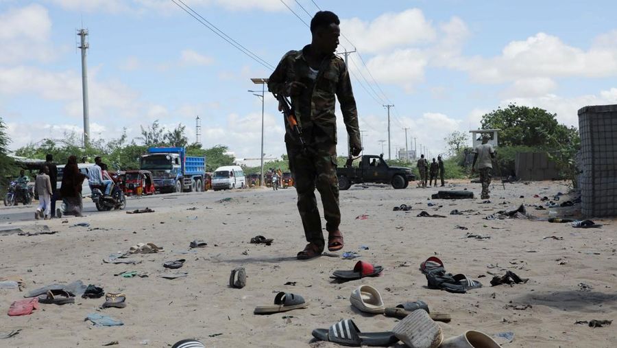 Seorang perwira militer Somalia berjalan melewati sepatu-sepatu yang ditinggalkan di lokasi ledakan yang menargetkan antrean rekrutan muda yang mendaftar di pangkalan militer Damanyo di distrik Hodan, Mogadishu, Somalia, 18 Mei 2025. Seorang perwira militer Somalia berjalan melewati sepatu-sepatu yang ditinggalkan di lokasi ledakan yang menargetkan antrean rekrutan muda yang mendaftar di pangkalan militer Damanyo di distrik Hodan, Mogadishu, Somalia, 18 Mei 2025. (REUTERS/Feisal Omar)